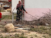 Her sister gathering twigs for her oven next door